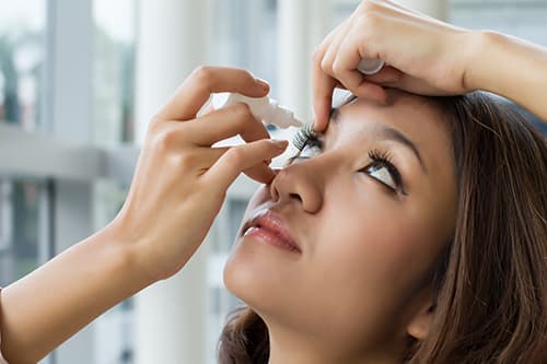 Woman using eyedrops for dry eyes