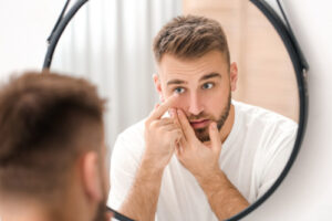 man applying contact lenses